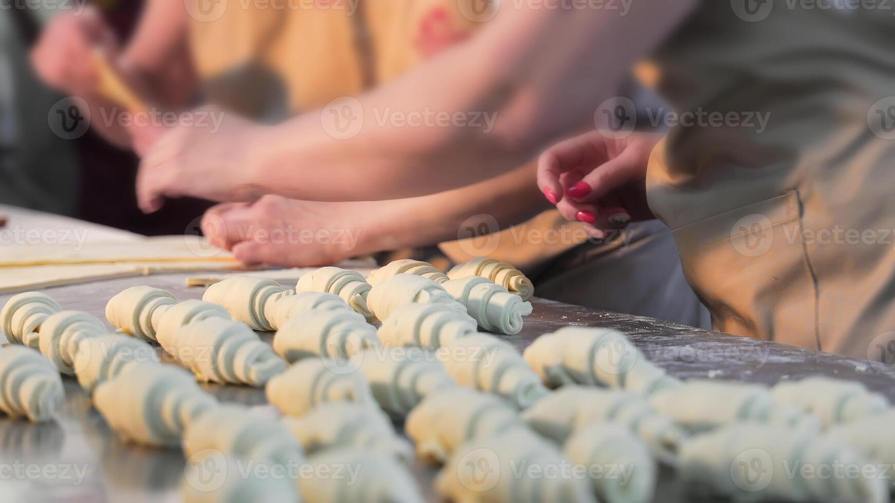 vrouw handen maken croissants, vormgeven deeg voor bagels, draaien de deeg met handen. bakken brood en bakkerij producten, croissants, bagels. dichtbij omhoog. foto