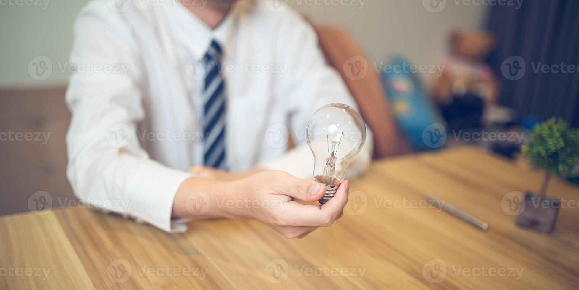 bedrijf professioneel Holding een licht lamp in een creatief brainstorming sessie, symboliseert ideeën en innovatie foto