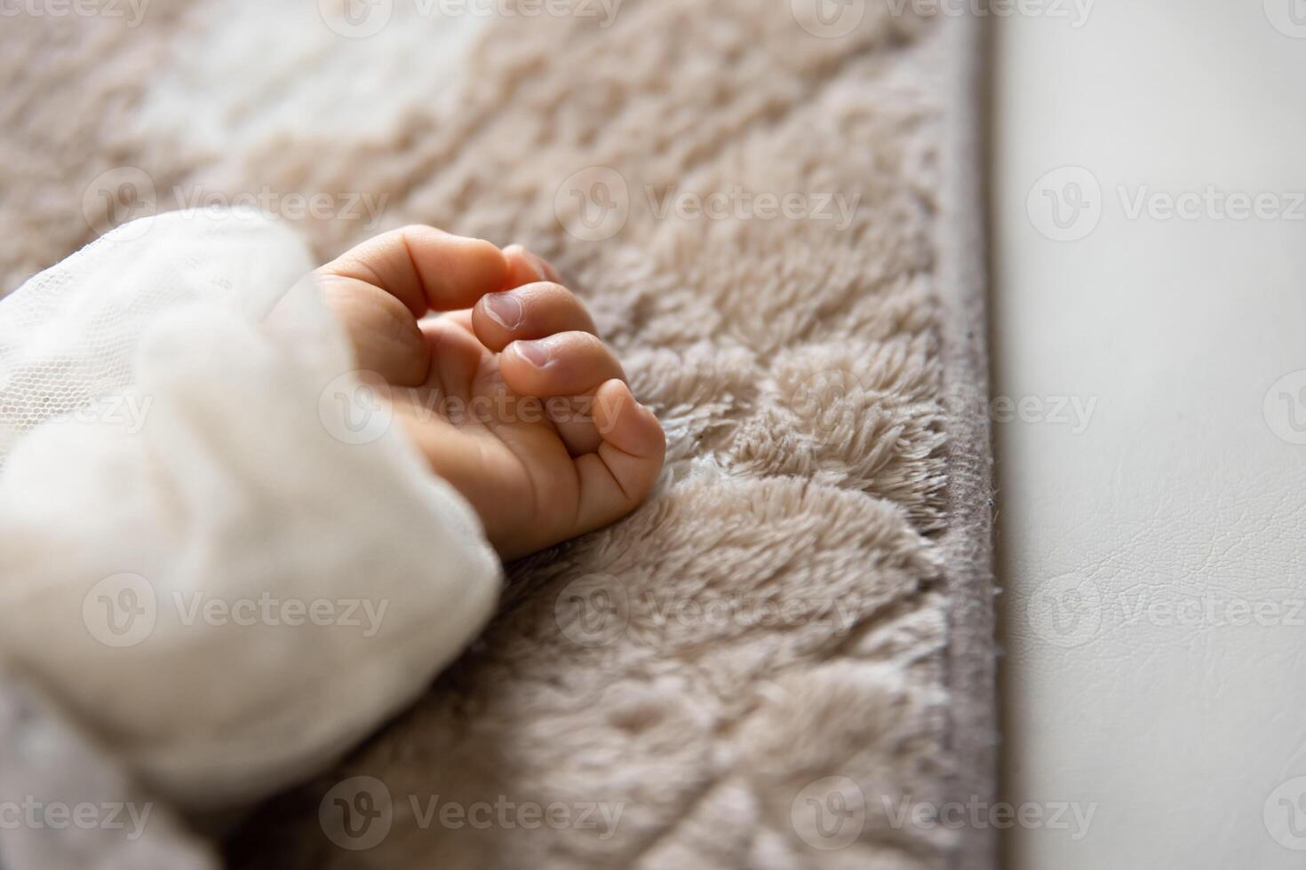 een links hand- van slapen Aziatisch baby Aan de tapijt foto