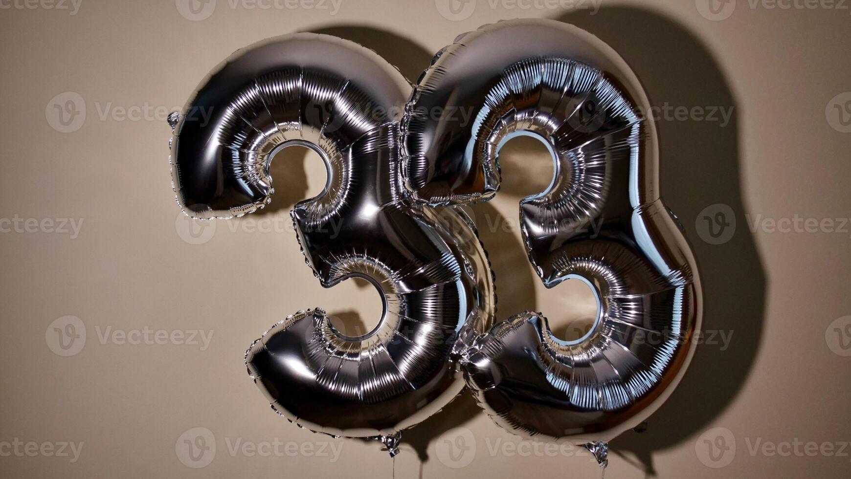partij gelukkig verjaardag drieëndertig met zilver grijs aantal . gel ballen 33 voor Gefeliciteerd vieringen vakantie. detailopname, Nee mensen foto