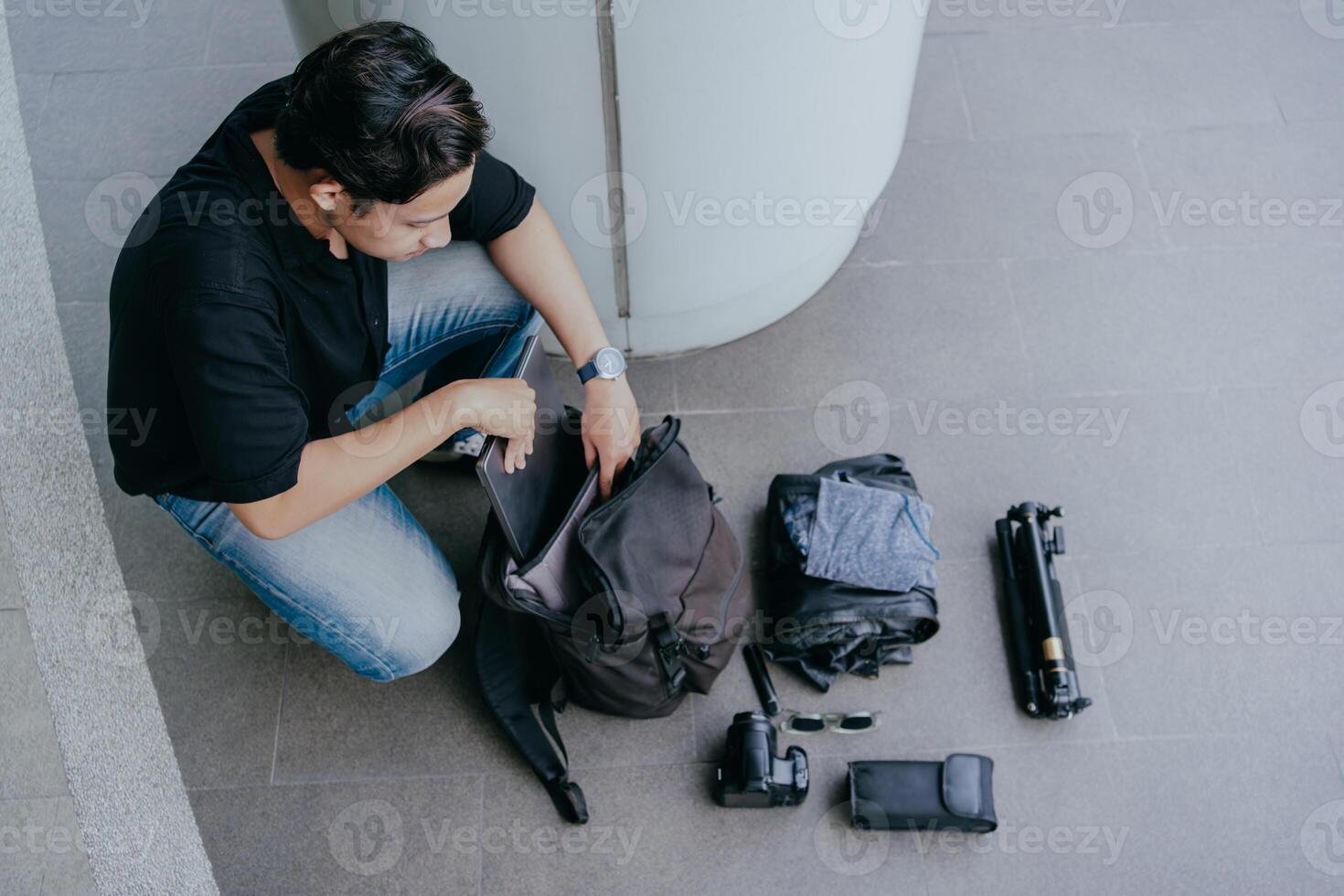 Indonesisch mannetje fotograaf is inpakken bagage en krijgen klaar naar reizen. vakantie reizen concept. foto