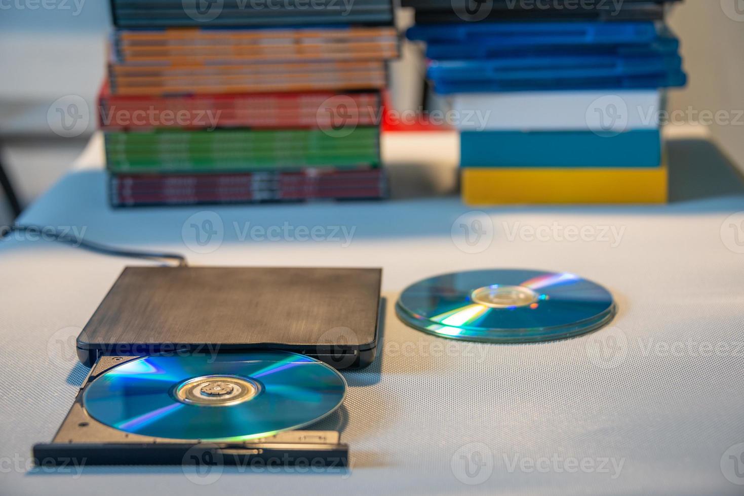 compacte stijlvolle videospeler voor cd- en dvd-schijven met een stapel van vele tv-serie filmschijven op de achtergrond. foto