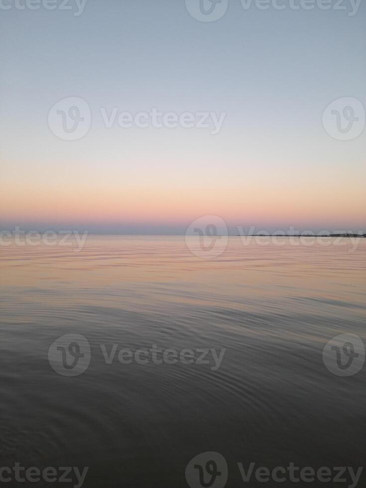 zonsondergang over- de stil zee foto