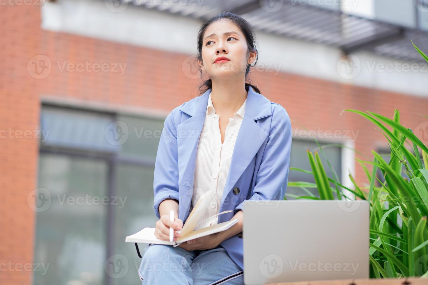 jonge aziatische vrouw die buiten werkt foto