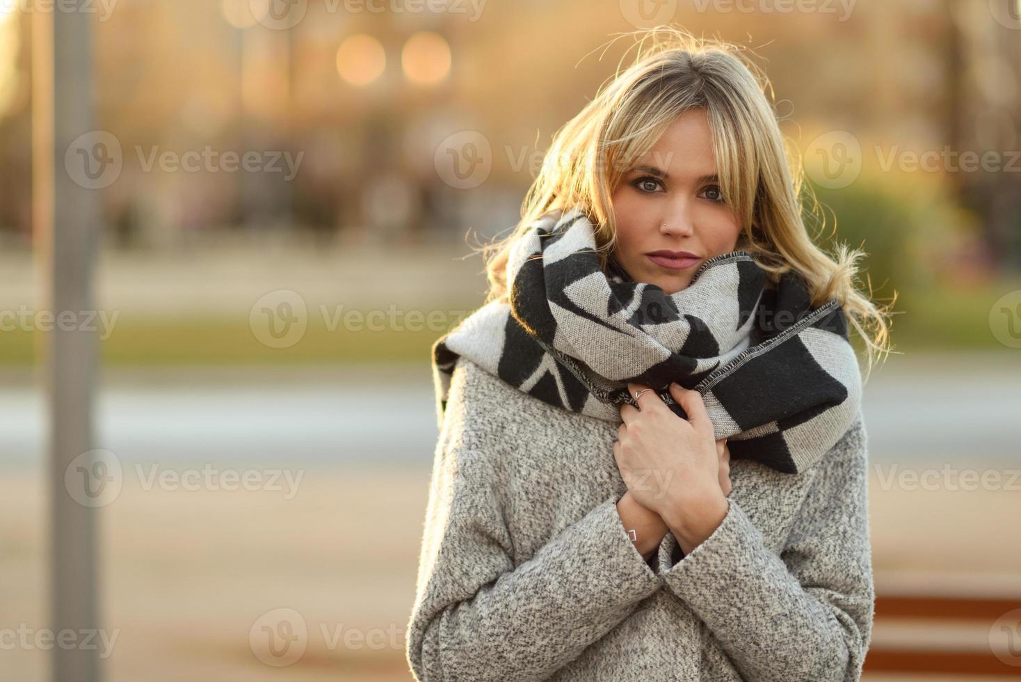 mooie jonge blonde vrouw in stedelijke achtergrond foto