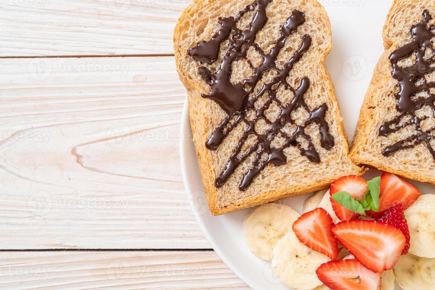 volkoren brood met verse banaan, aardbei en chocolade foto