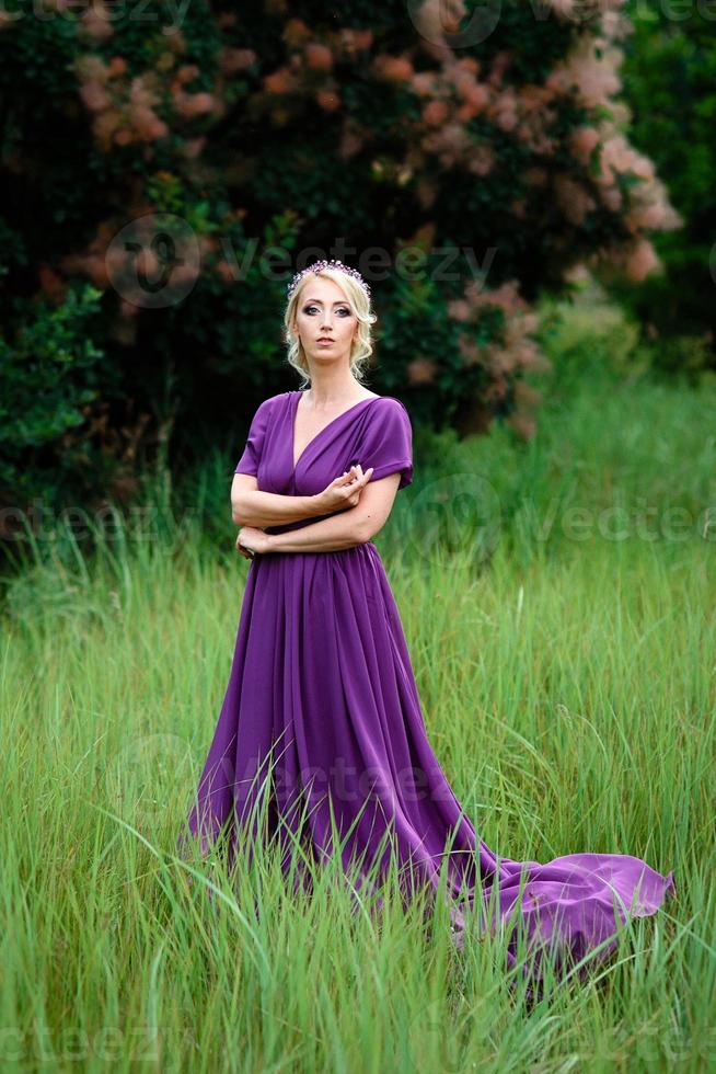 meisje model blond in een lila jurk met een boeket foto