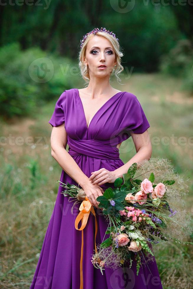 meisje model blond in een lila jurk met een boeket foto