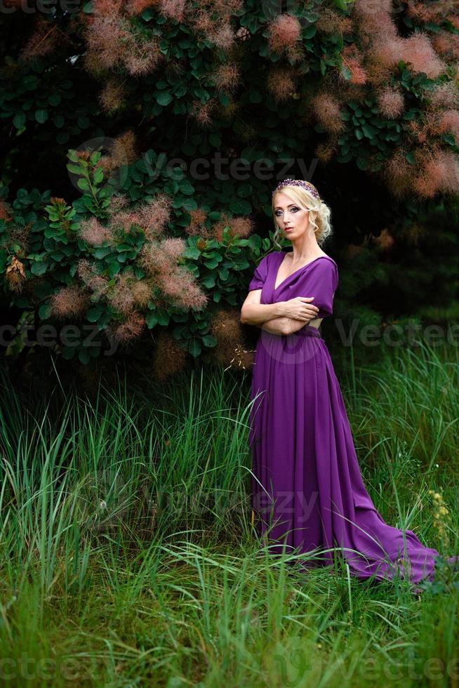 meisje model blond in een lila jurk met een boeket foto