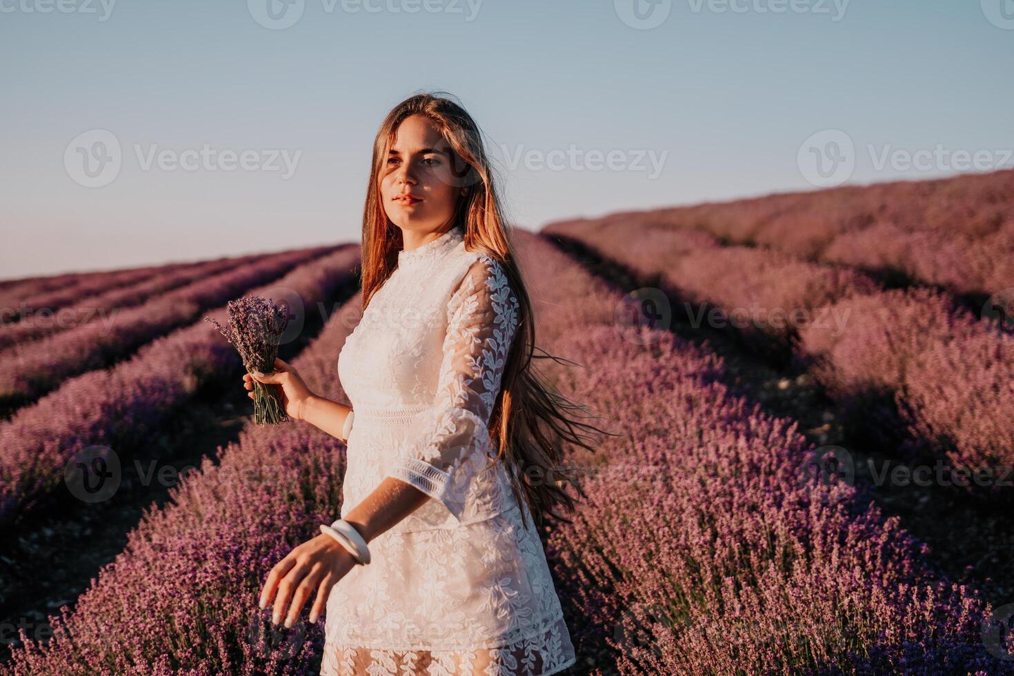 vrouw lavendel veld. gelukkig zorgeloos vrouw in een wit jurk wandelen in een lavendel veld- en ruiken een lavendel boeket Aan zonsondergang. ideaal voor warm en inspirerend concepten in reislust en reizen. foto