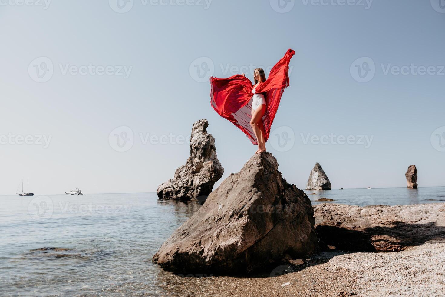 vrouw reizen zee. jong gelukkig vrouw in een lang rood jurk poseren Aan een strand in de buurt de zee Aan achtergrond van vulkanisch rotsen, Leuk vinden in IJsland, sharing reizen avontuur reis foto