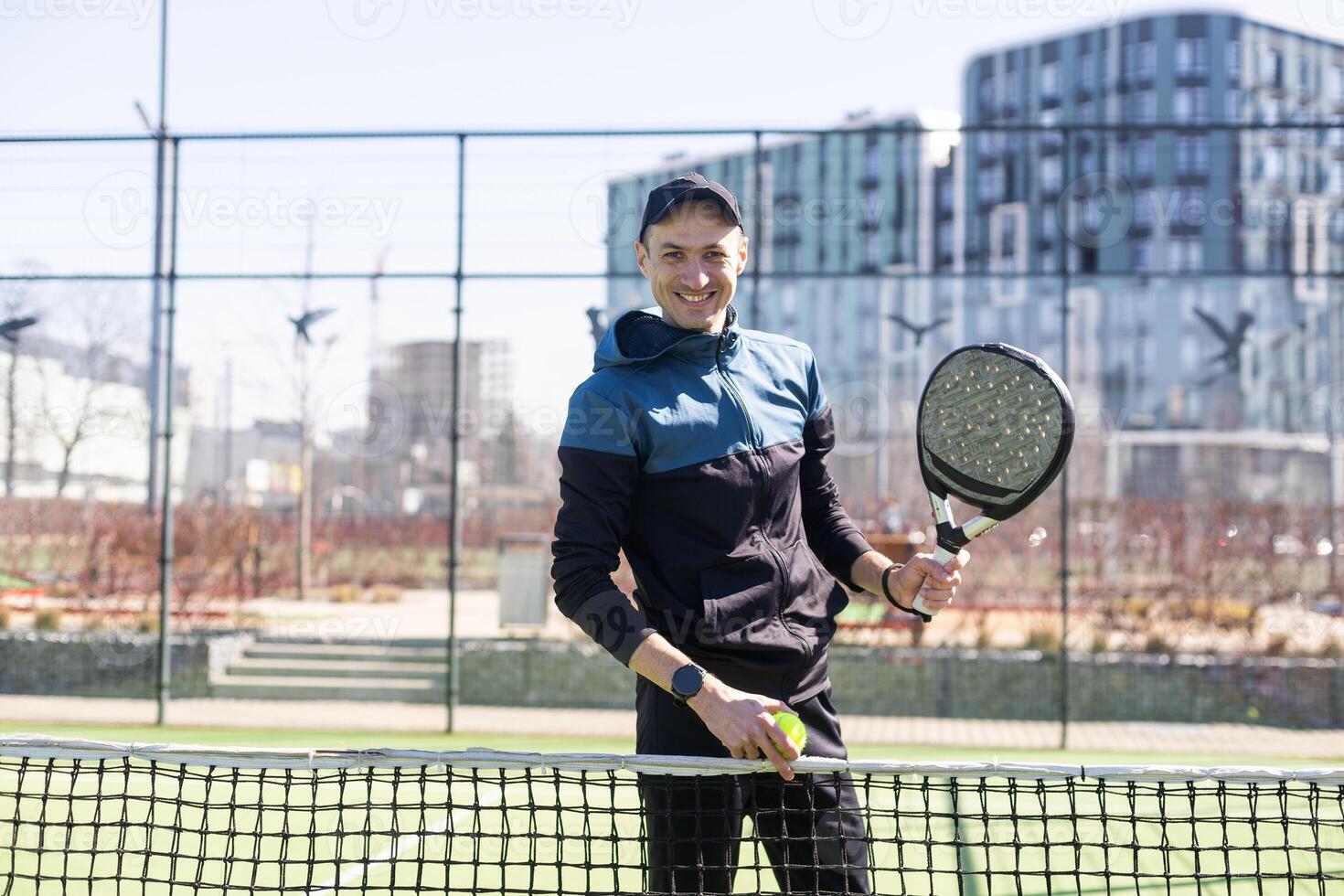 Mens spelen padel in een groen gras padel rechtbank binnen- achter de netto foto