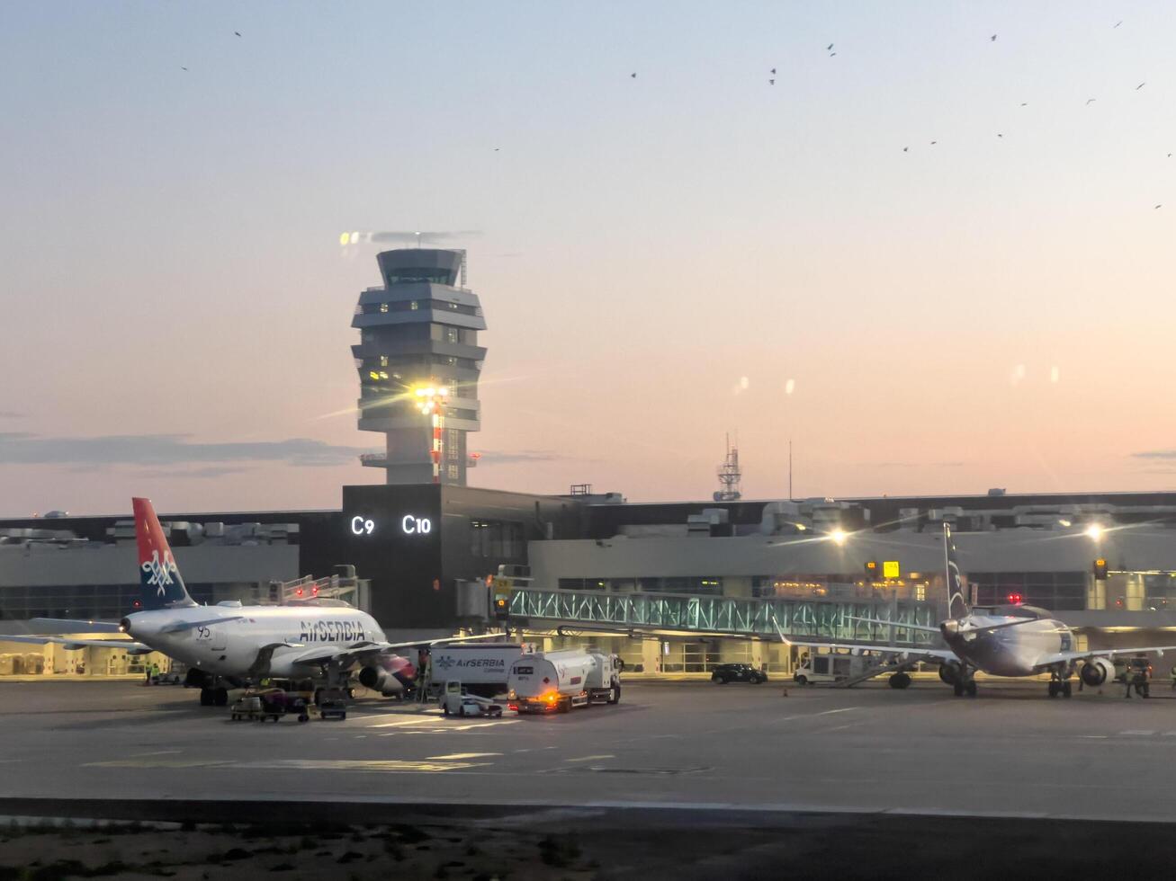 fijn, Griekenland - 20 augustus 2023. passagier vliegtuigen staan in de buurt luchthaven terminals Bij zonsondergang foto