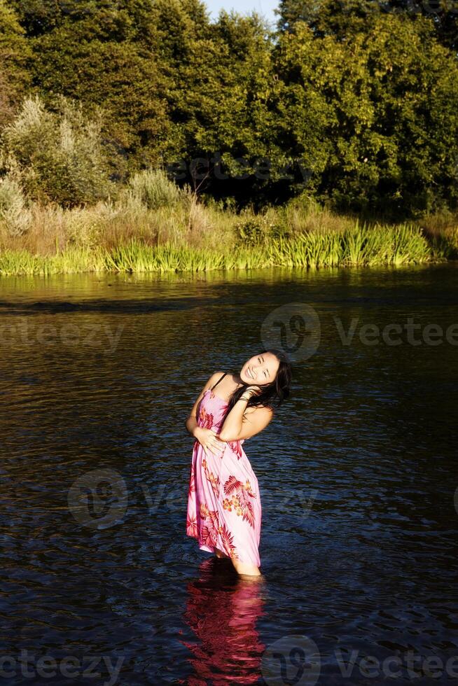 aantrekkelijk Japans Amerikaans vrouw staand in rivier- foto