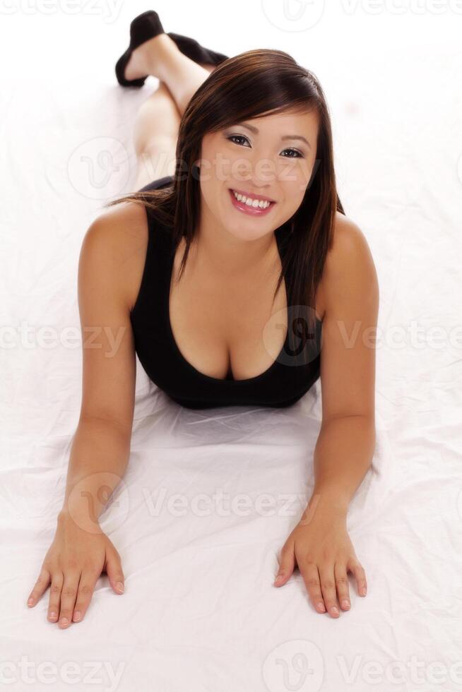 glimlachen Aziatisch Amerikaans tiener meisje Aan maag foto