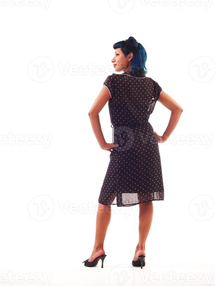aantrekkelijk spaans vrouw staand in zwart en wit jurk terug foto