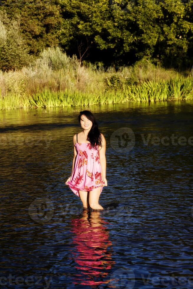 glimlachen Japans Amerikaans vrouw staand in rivier- foto