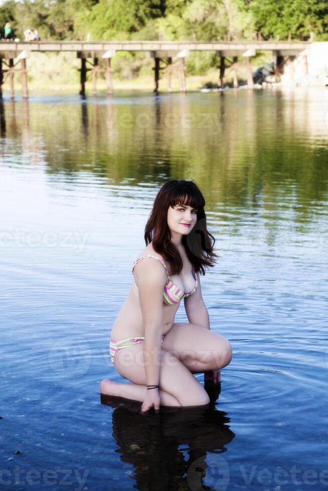 mollig Kaukasisch tiener in rivier- met bikini foto