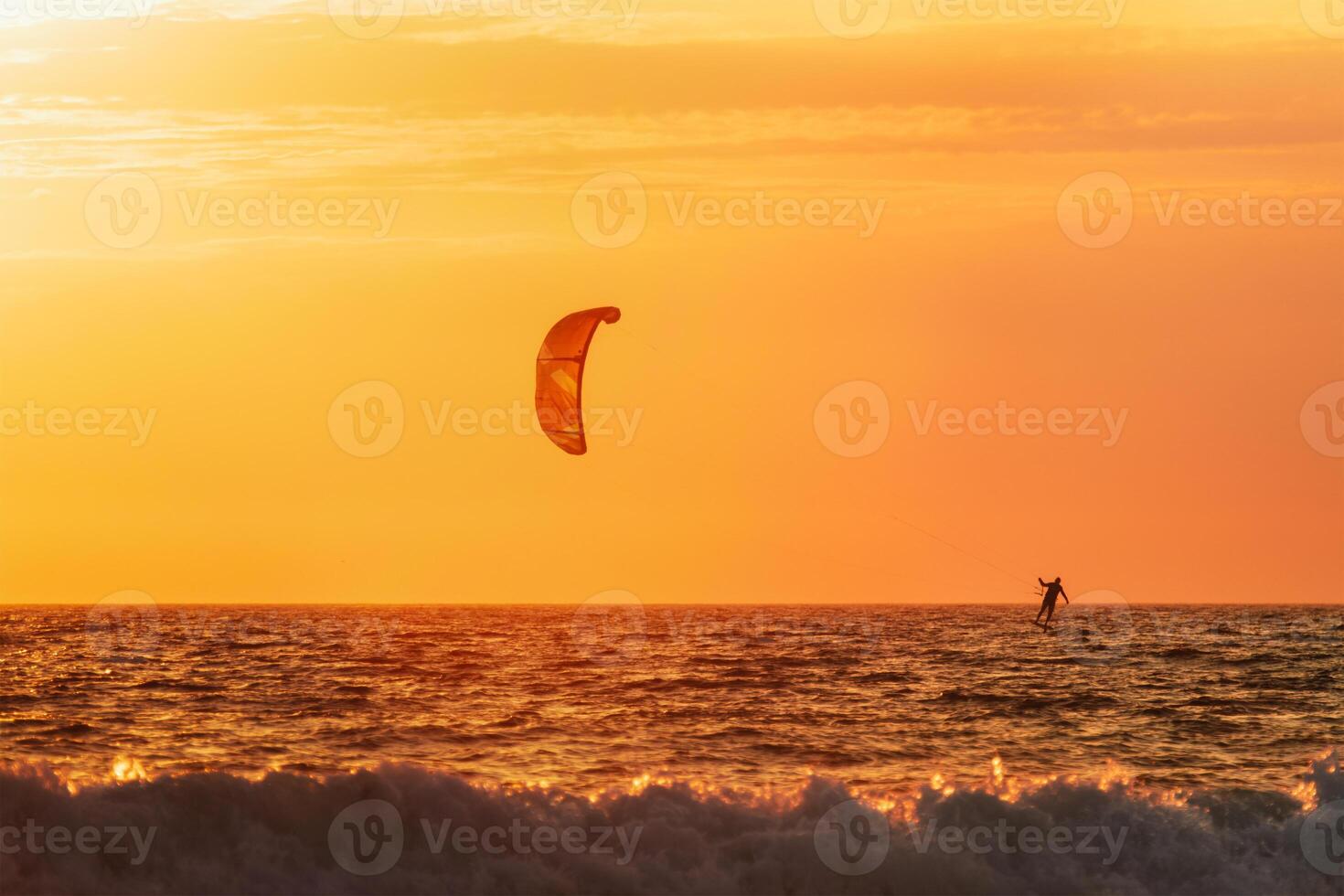 kiteboarden kitesurfen kiteboarder kitesurfer vliegers silhouet in de oceaan Aan zonsondergang foto