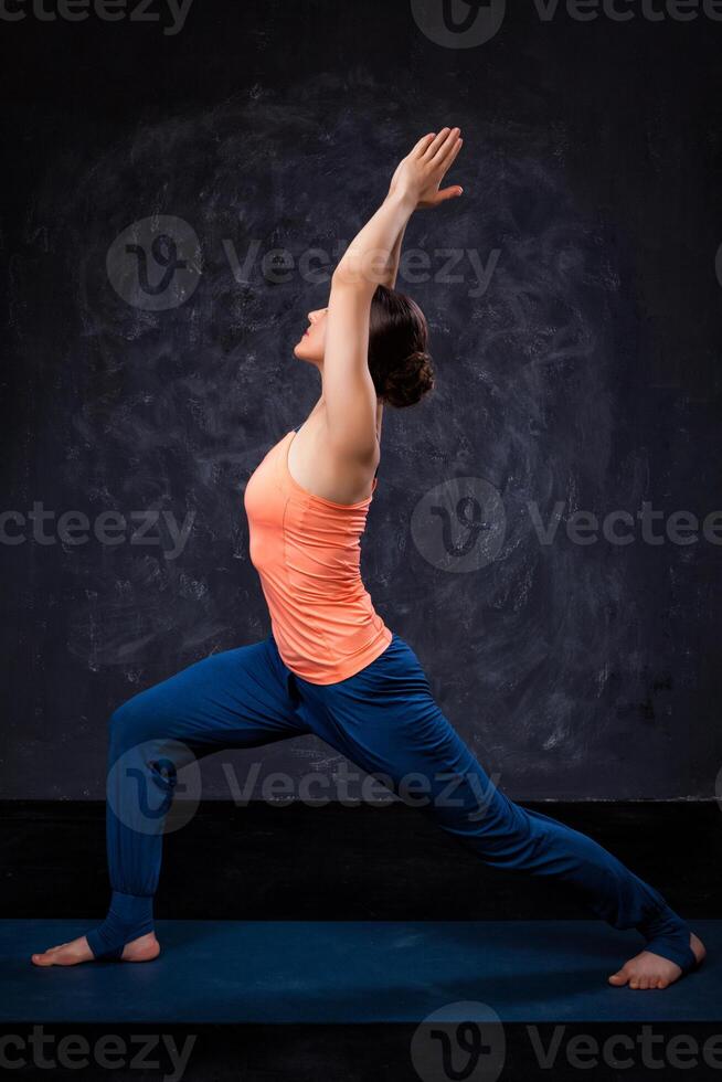 vrouw praktijken yoga asana utthita virabhadras foto