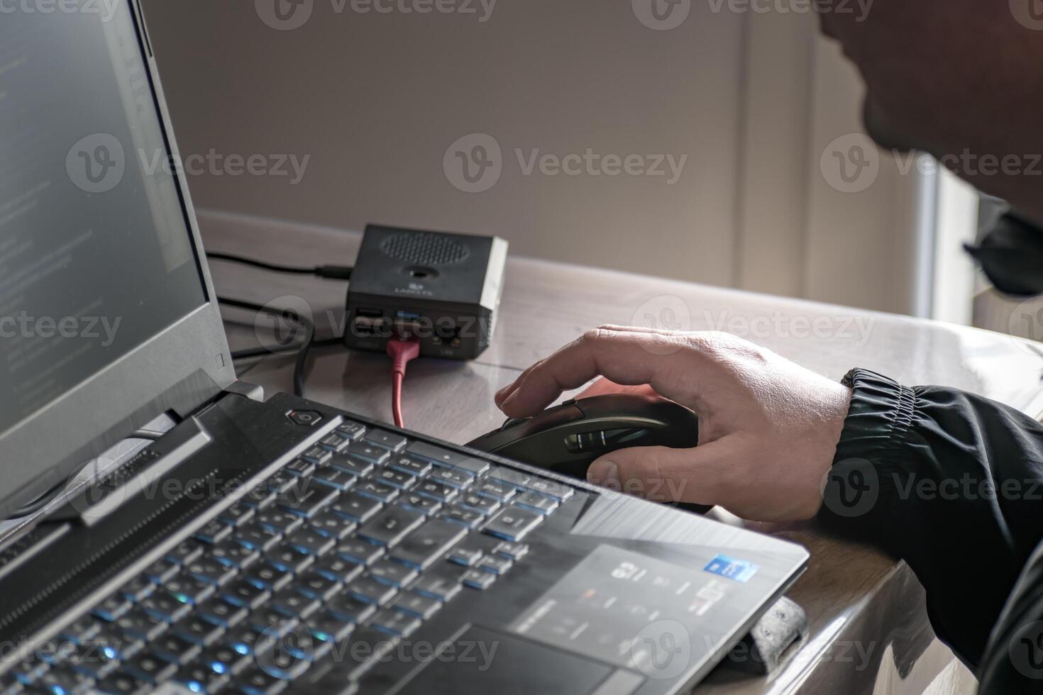 dichtbij omhoog van man's hand- gebruik makend van draadloze muis en laptop computer met blauw verlicht toetsenbord foto