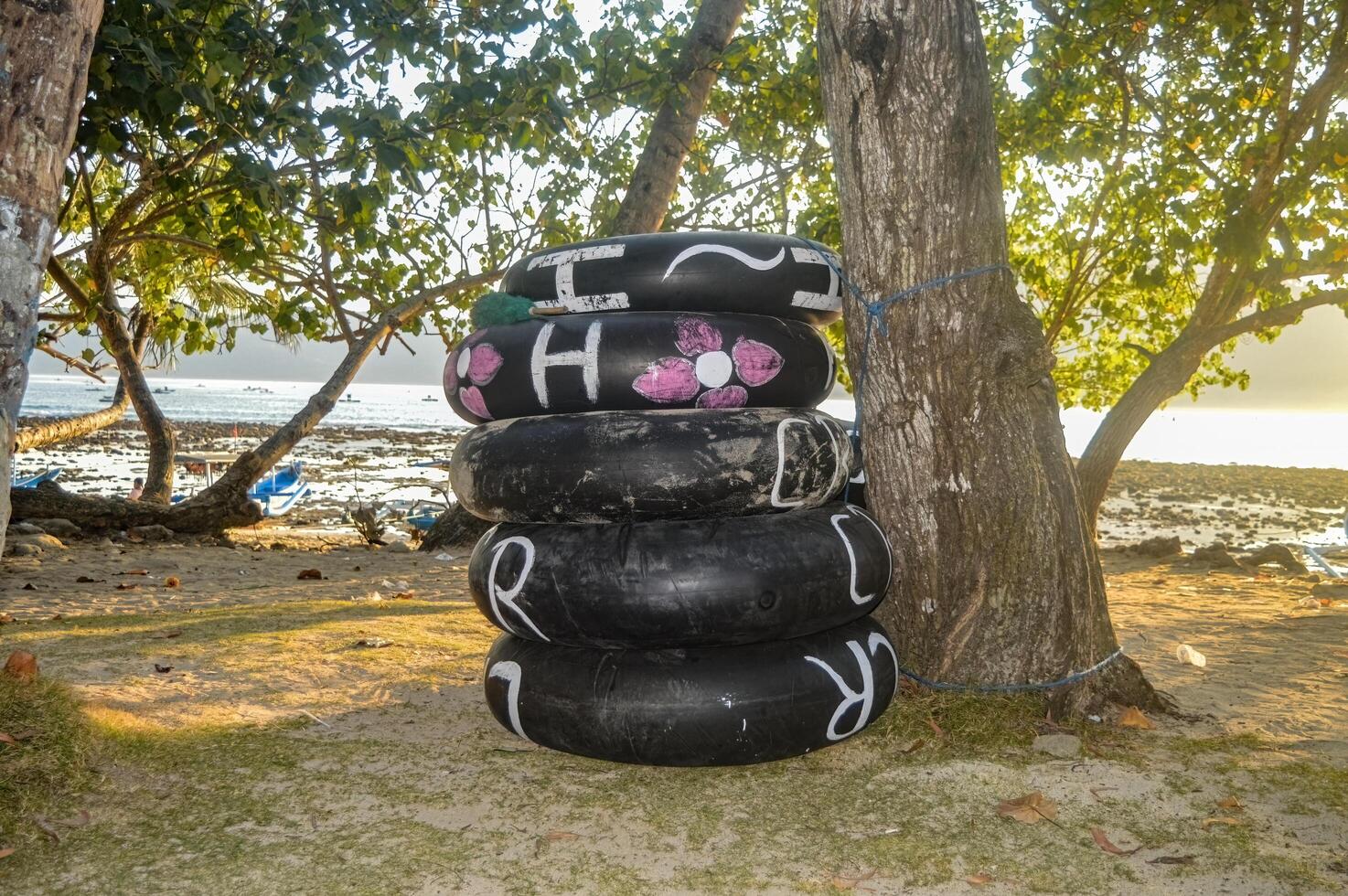 stapel van gebruikt banden gebruikt net zo boeien Aan karanggongso strand foto