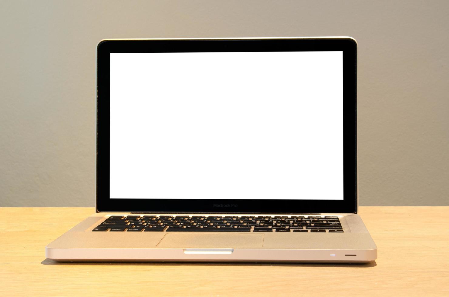 mockup van een computerlaptop op een bureau met een leeg wit scherm. foto