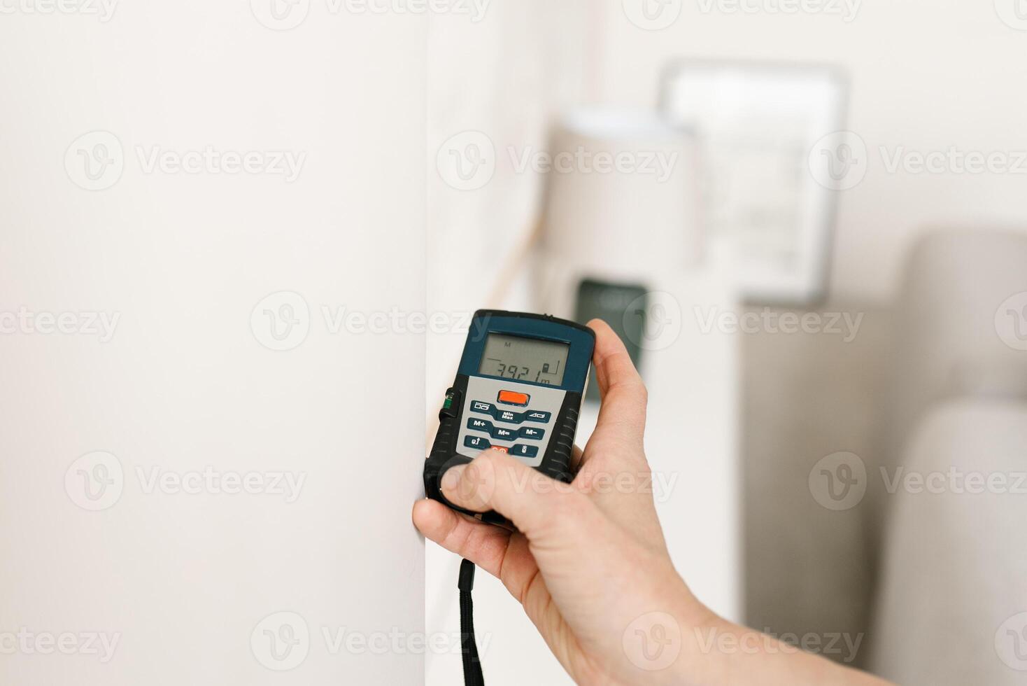 laser afstandsmeter in de handen van een vrouw. een ingenieur Holding een laser afstandsmeter. dichtbij omhoog van een meten apparaat in een huis. ontwerper gebruik makend van een elektronisch afstandsmeter in een kamer foto