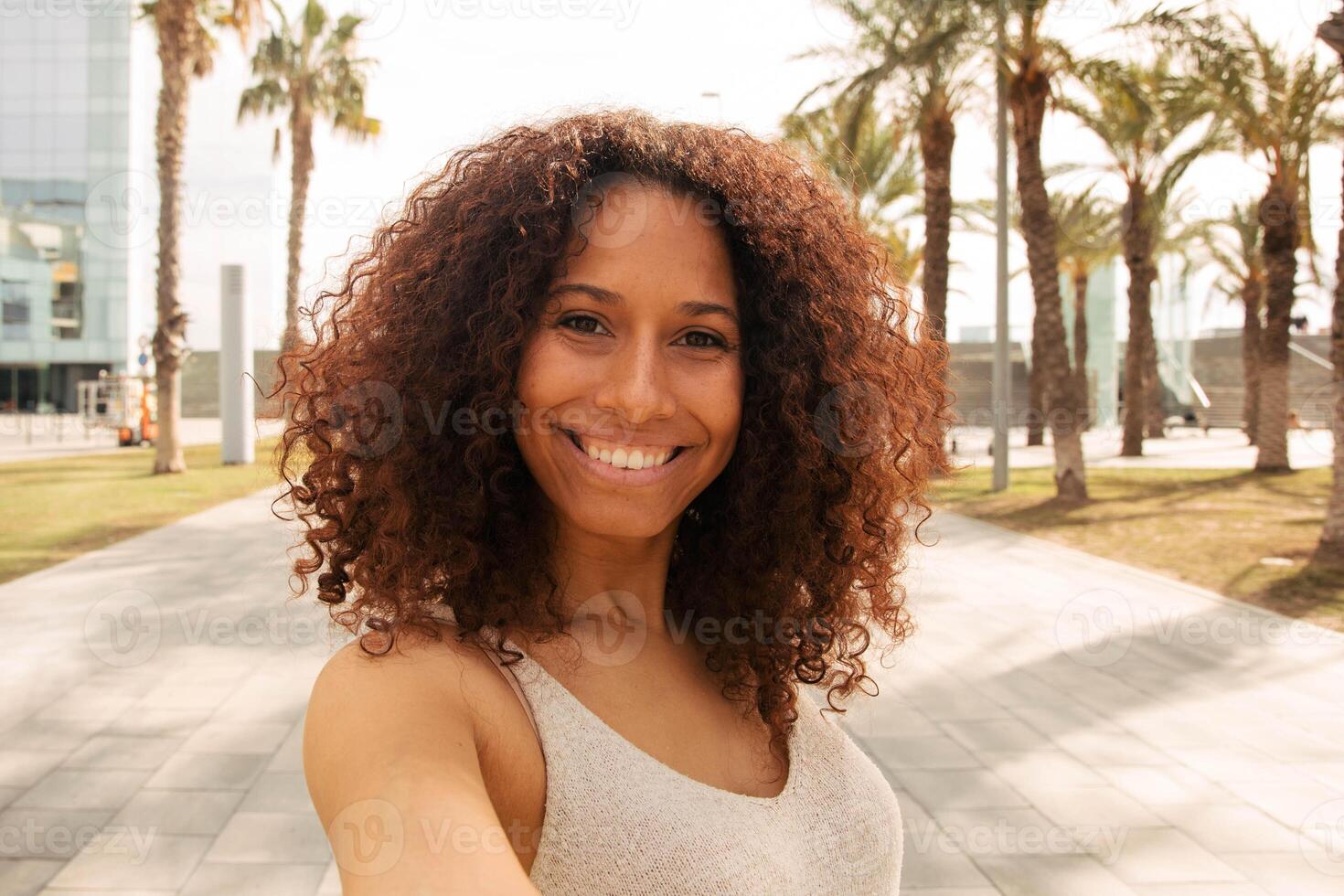 portret van vrolijk mooi afro Latijns vrouw poseren en nemen de camera foto