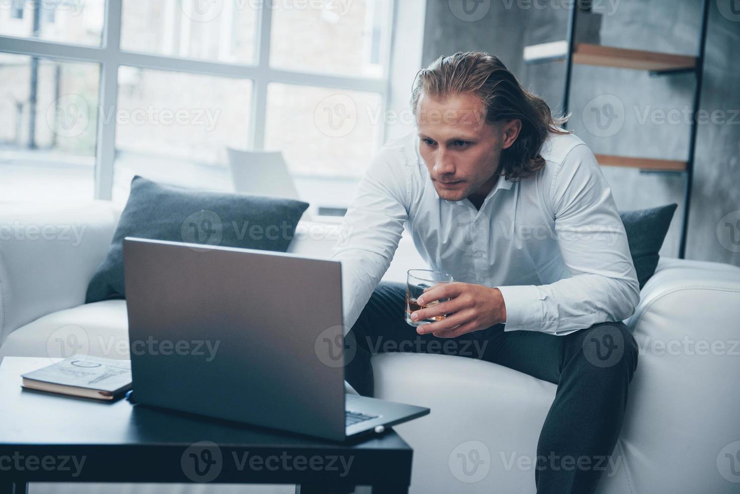 zakenman die met een notitieboekje werkt met een drankje in de hand? foto