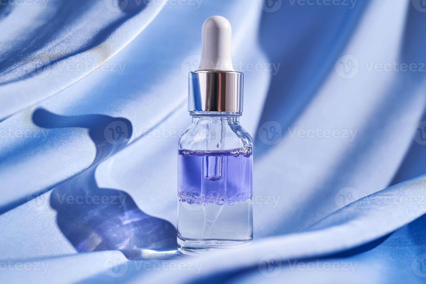 tweecomponenten gelaats serum Aan een blauw zijde achtergrond. foto