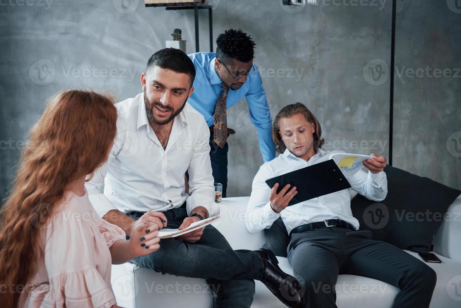 zekerheid van documenten controleren. groep multiraciale kantoormedewerkers in formele kleding praten over taken en plannen foto