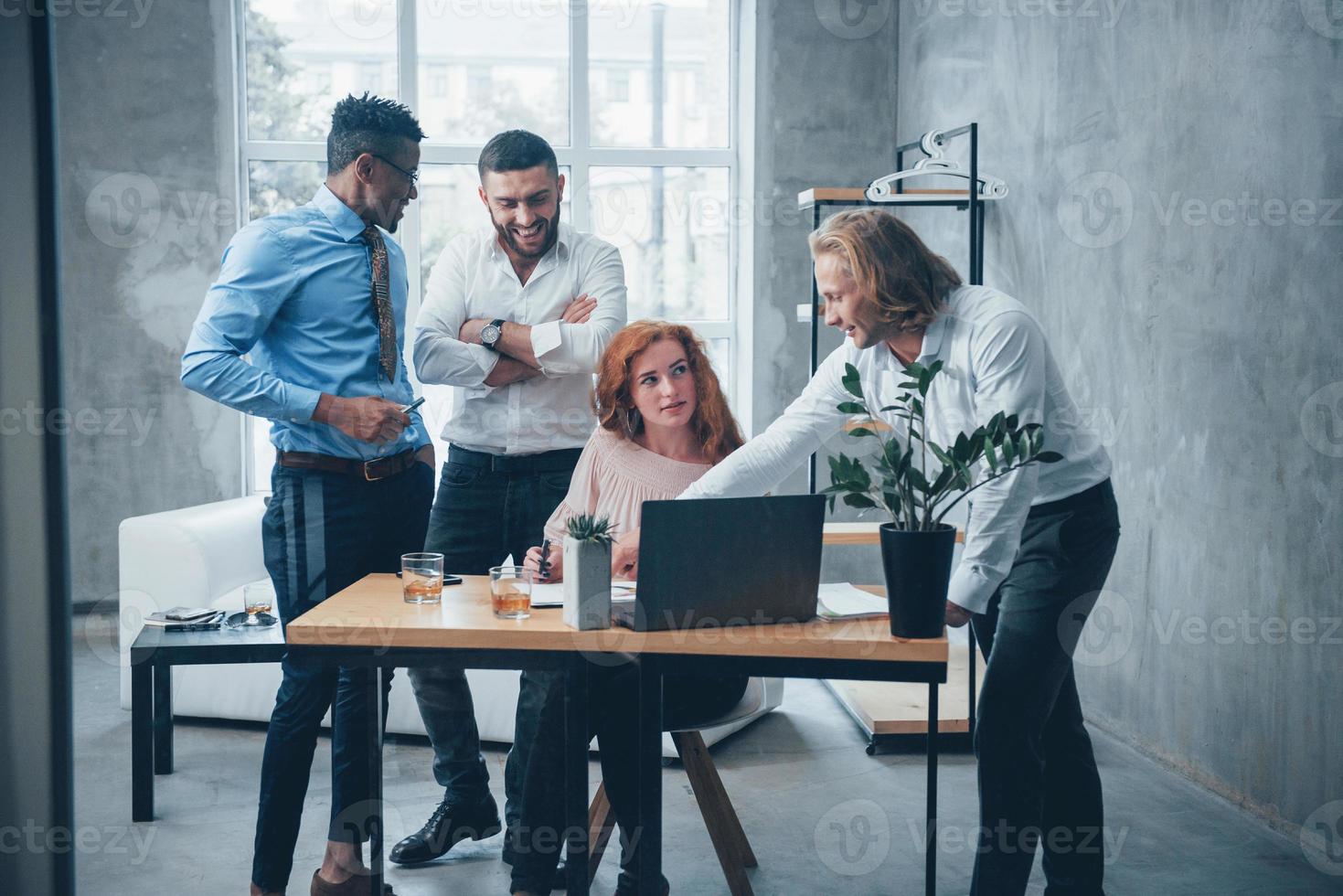 jong business team werkt aan een project met laptop op tafel en glimlacht foto