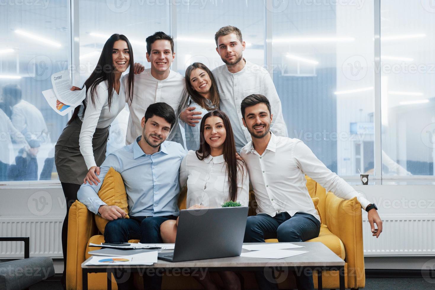 leuke vriendelijke sfeer. portret van een jong team in klassieke kleding in het moderne, goed verlichte kantoor? foto