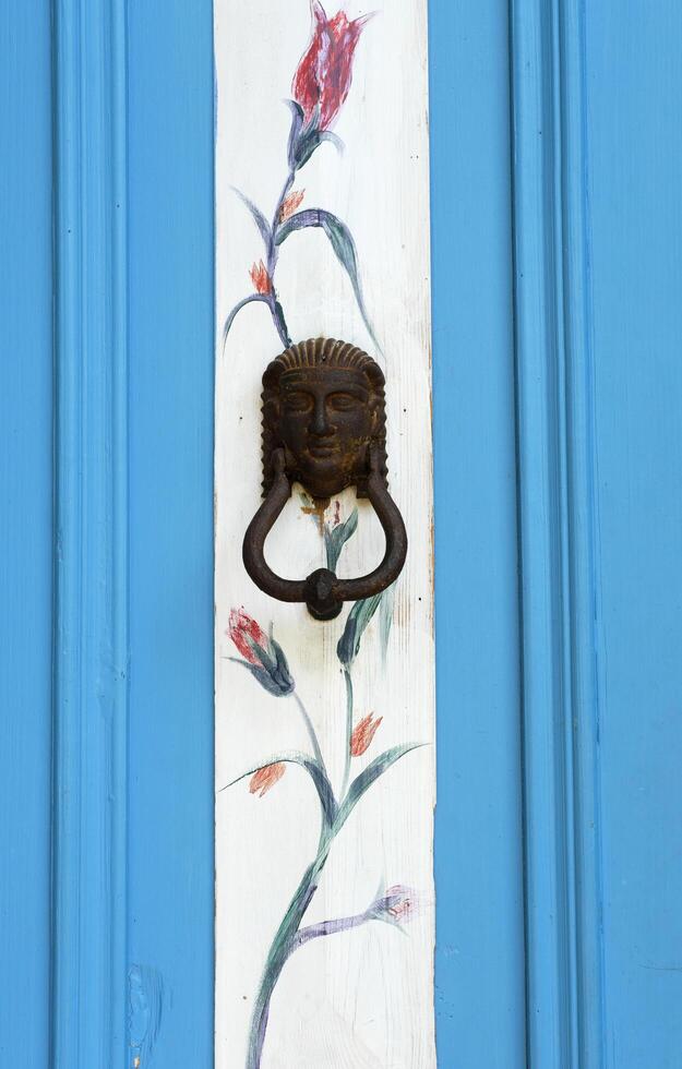 blauw deur met ijzer omgaan met en bloemen schilderen. adatepe, kalkoen - augustus 21, 2023 foto