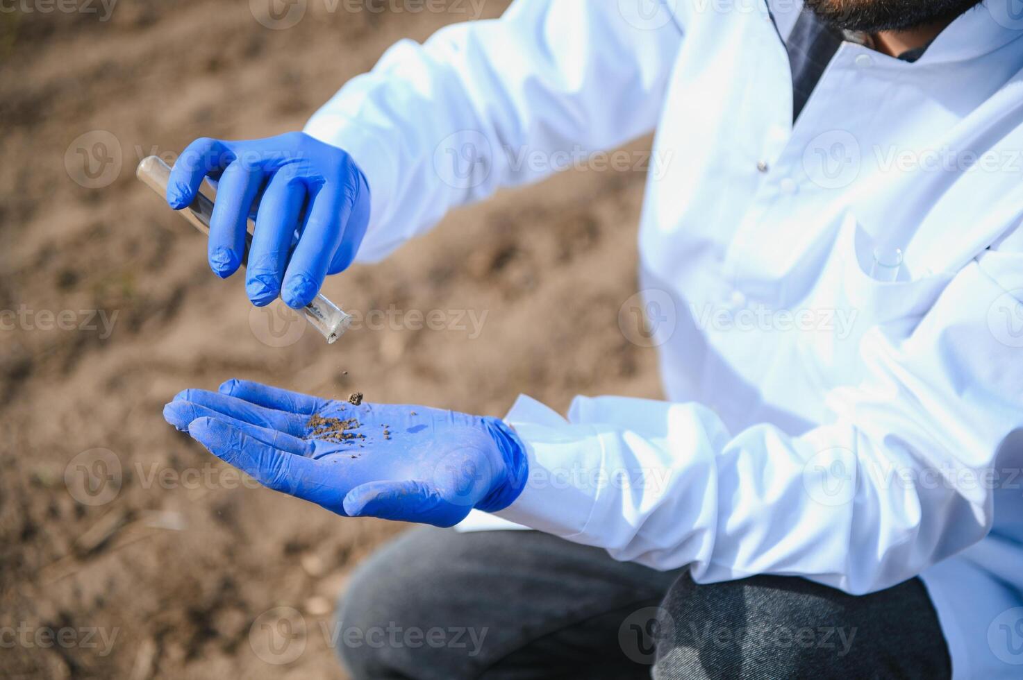 agronoom aan het studeren monsters van bodem in veld- foto