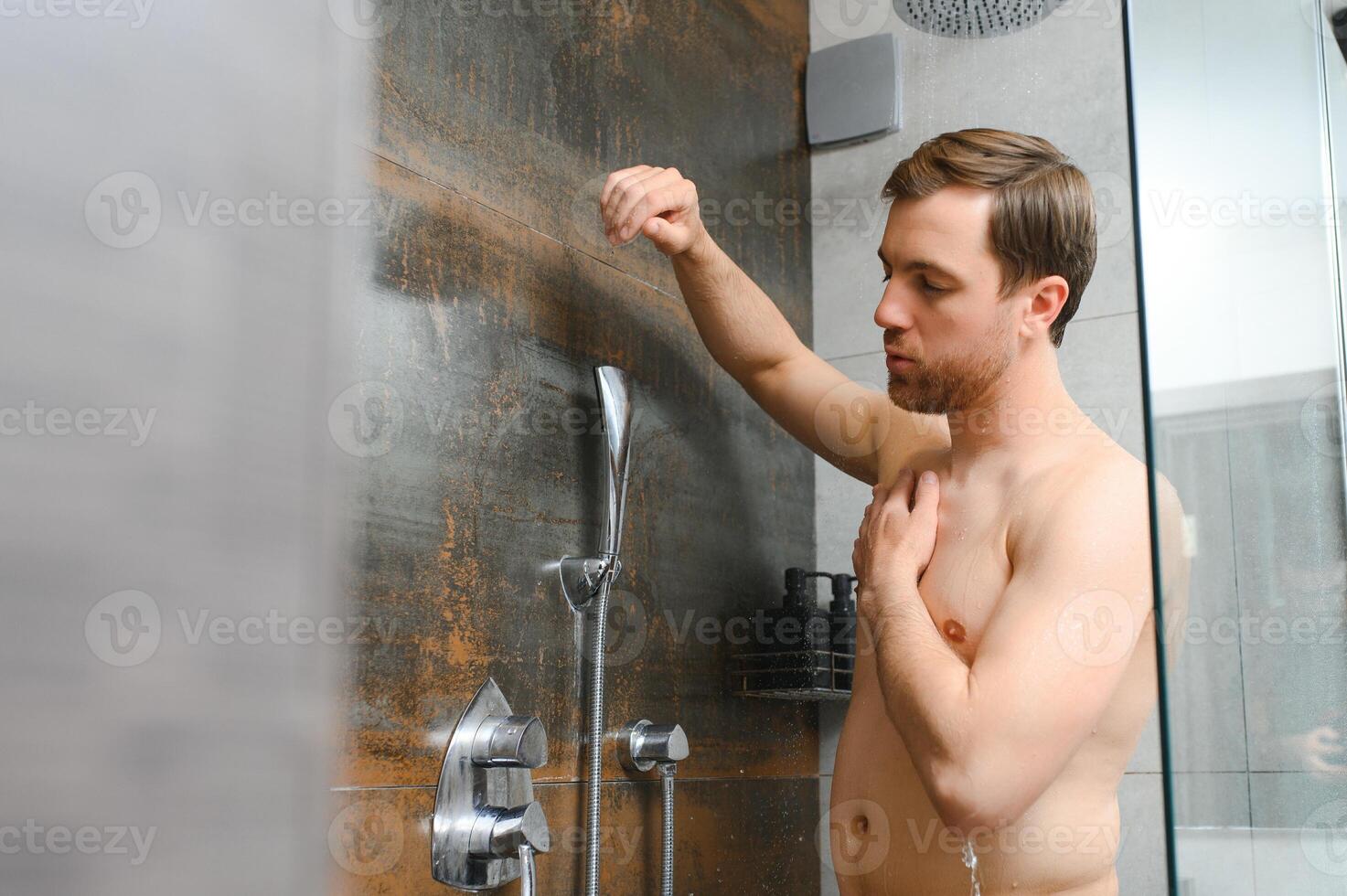 knap Mens nemen douche in modern badkamer foto