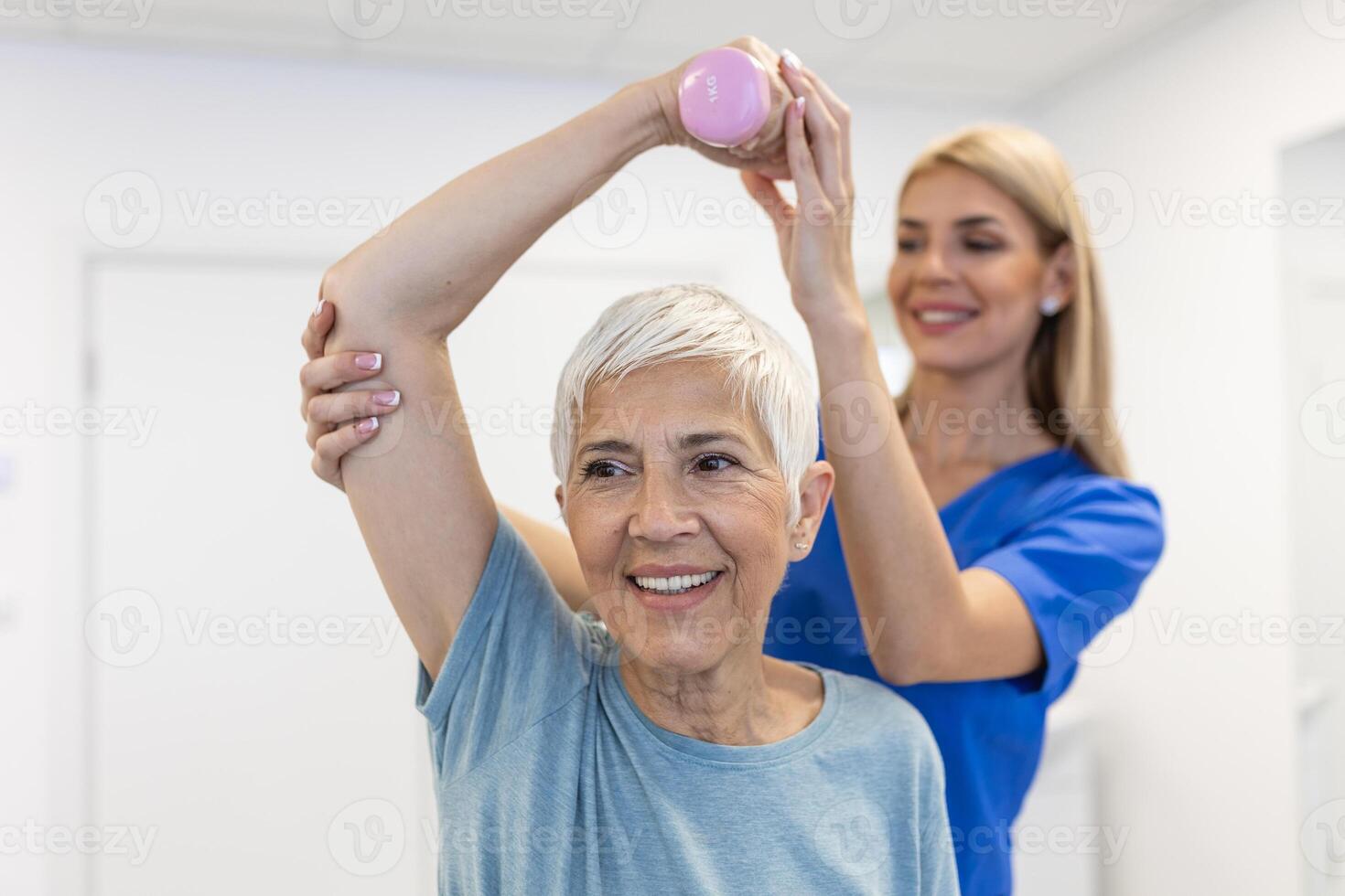 fysiotherapeut vrouw geven oefening met halter behandeling over arm en schouder van senior vrouw geduldig fysiek behandeling concept foto