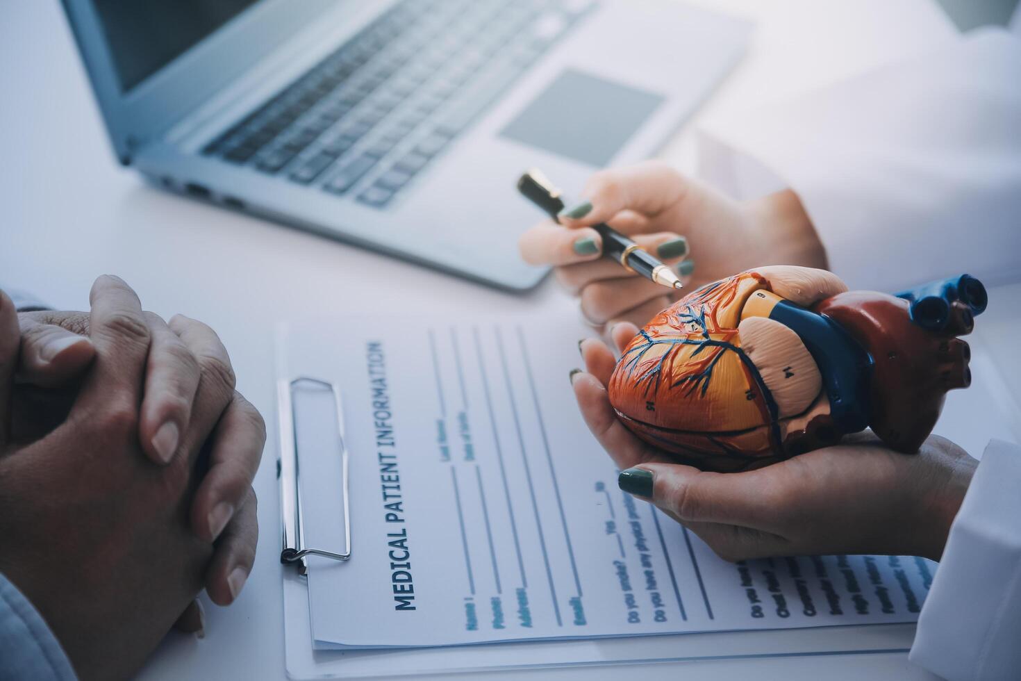 dokter uitleggen hart naar ouderen geduldig. dokter uitleggen de hart model. artsen pen punt naar een model- van de hart foto