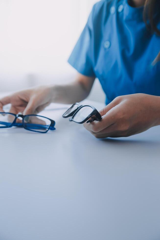 detailopname van Aziatisch vrouw dokter pratend met ouderen geduldig tonen oogbol model- en uitleggen oog ziekte in ziekenhuis foto