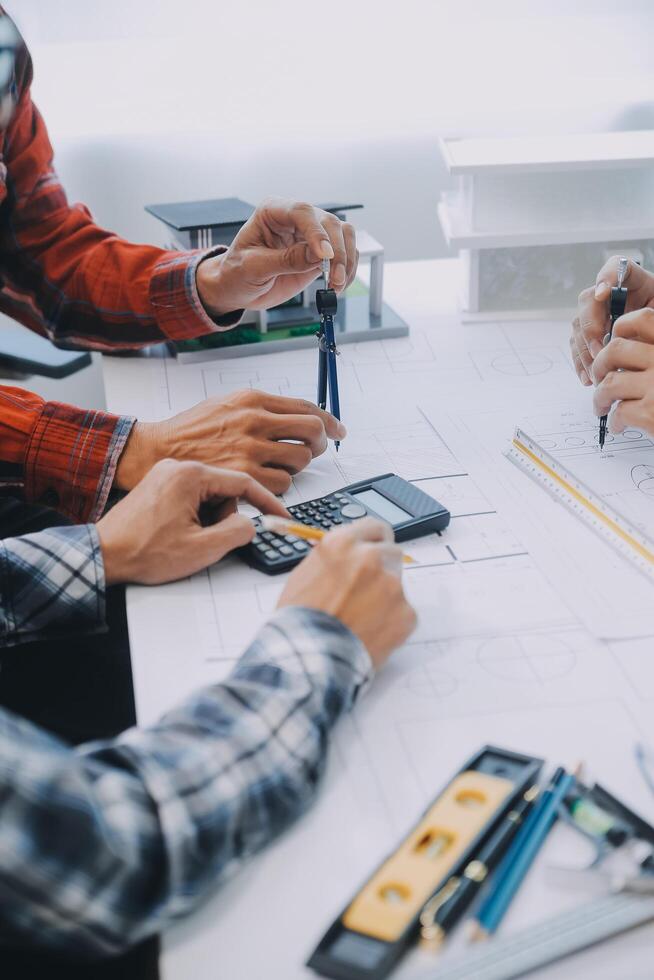 ingenieur mensen vergadering werken en richten Bij een tekeningen in kantoor voor bespreken. bouwkunde gereedschap en bouw concept. foto