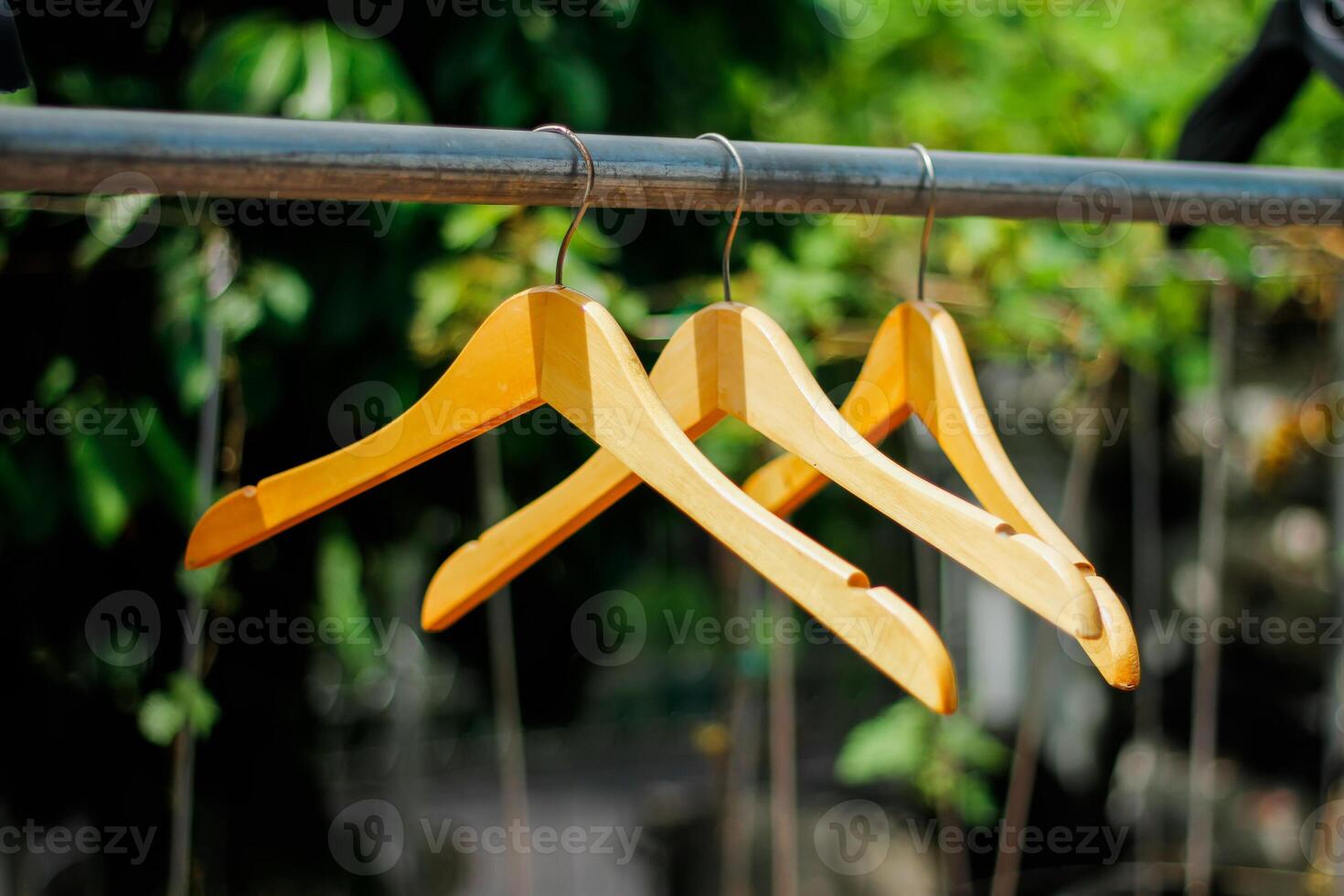 houten kleren hanger met een natuurlijk bladerrijk achtergrond in de tuin foto