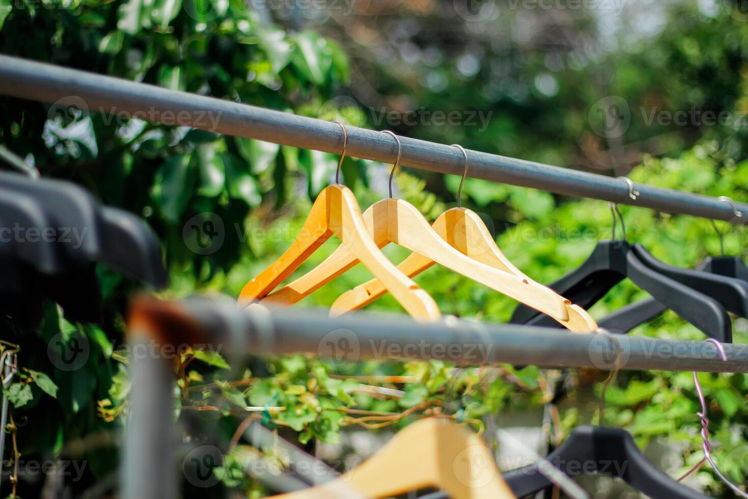 houten kleren hanger met een natuurlijk bladerrijk achtergrond in de tuin foto