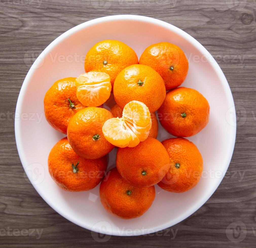 vers mandarijn- sinaasappels fruit of mandarijnen Aan een houten tafel foto