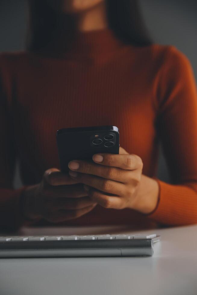 Aziatische zakenvrouw die een laptopcomputer gebruikt en op kantoor werkt met een rekenmachinedocument op het bureau, planning analyseert van het financiële rapport, businessplaninvestering, financiële analyseconcept. foto