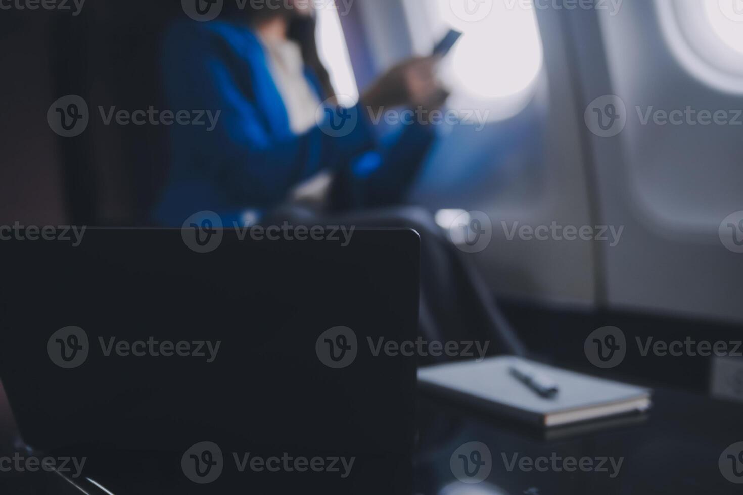 gebruik makend van mobiel en laptop, attent Aziatisch mensen vrouw persoon aan boord, vliegtuig venster, perfect vastleggen de verwachting en opwinding van vakantie reizen. Chinese, Japans mensen. foto