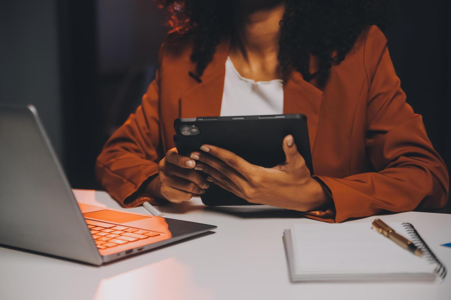 vrouw zittend Bij haar bureau in huis kantoor werken laat Bij nacht gebruik makend van laptop computer vrouw web ontwerper werken na een tijdje foto