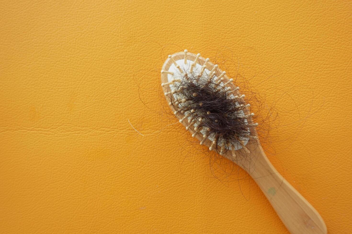 een borstel met verloren haar- Aan oranje kleur achtergrond foto