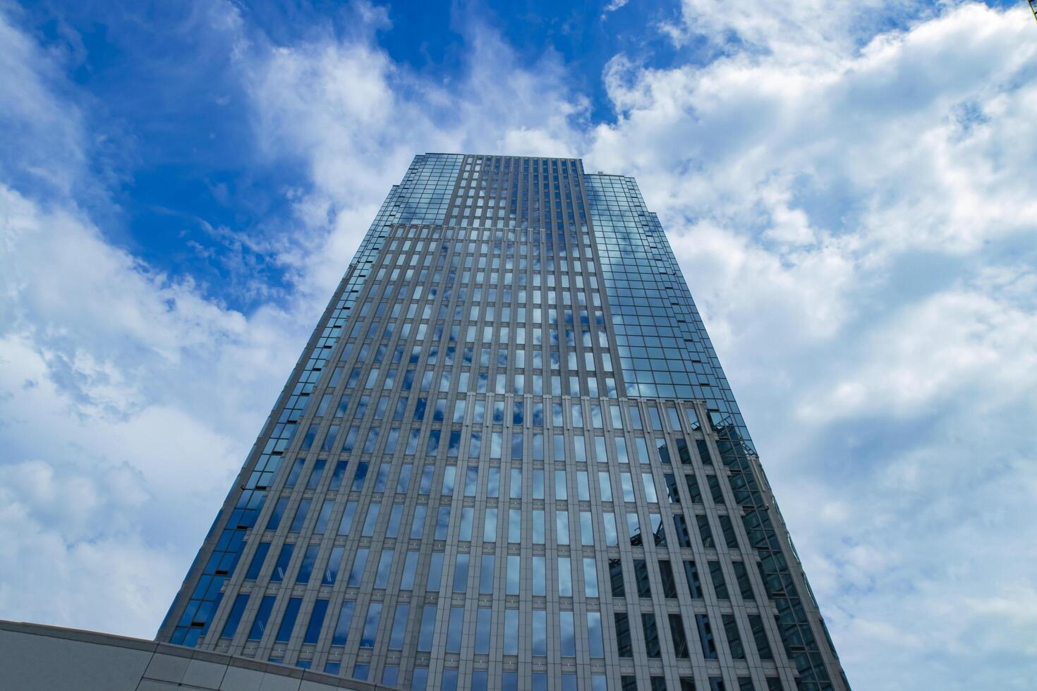 een wolk reflecterend de gebouw in de bedrijf stad- breed schot foto