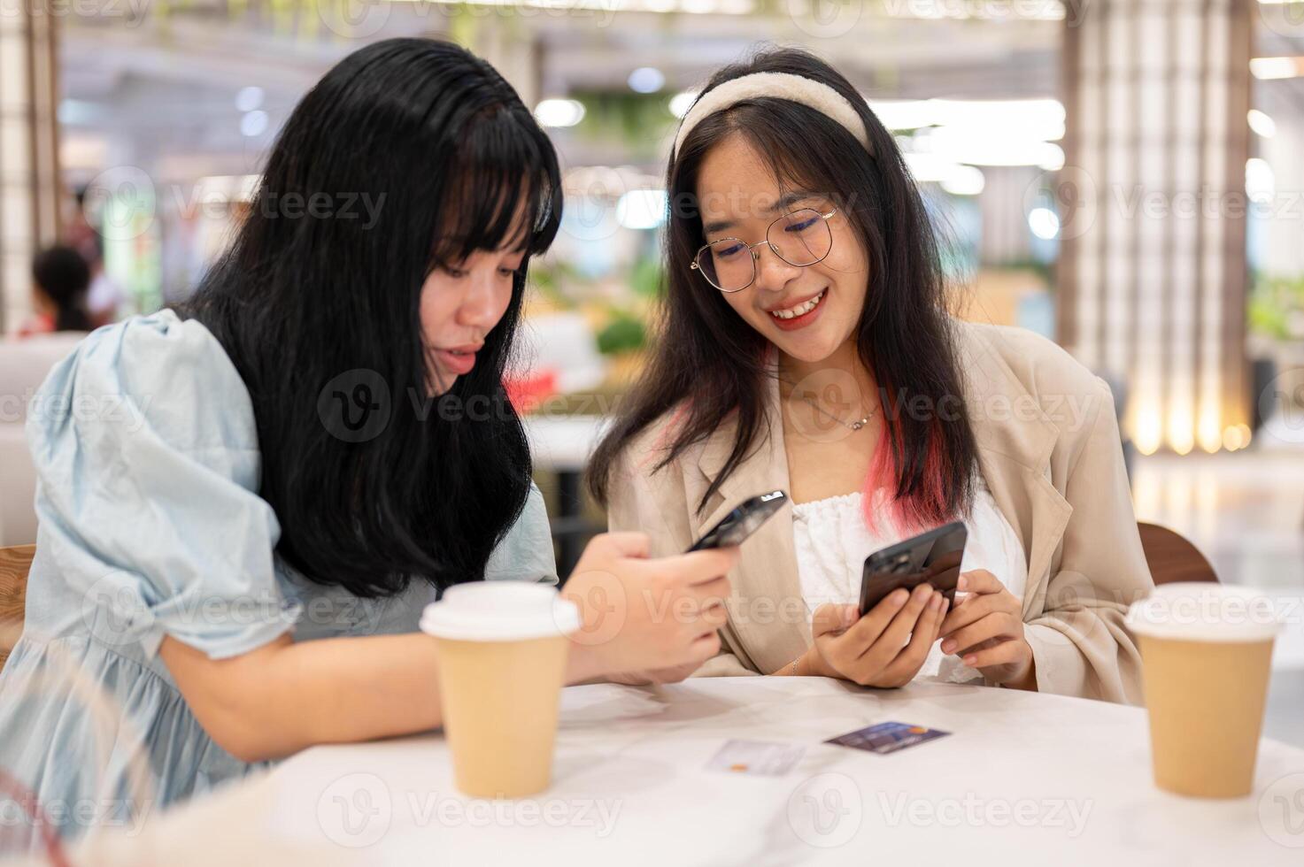twee gelukkig jong Aziatisch vrouw vrienden zijn hangende uit samen Bij de boodschappen doen winkelcentrum Aan de weekend. foto